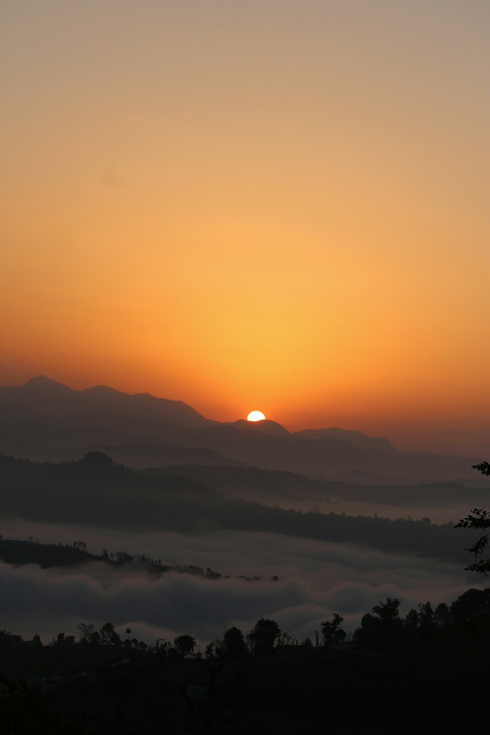 Sun rising over layered hills