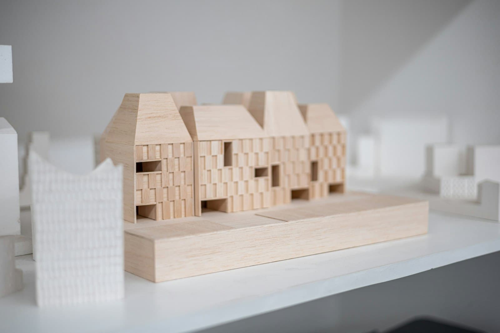 A pale wooden architectural model of a small building
